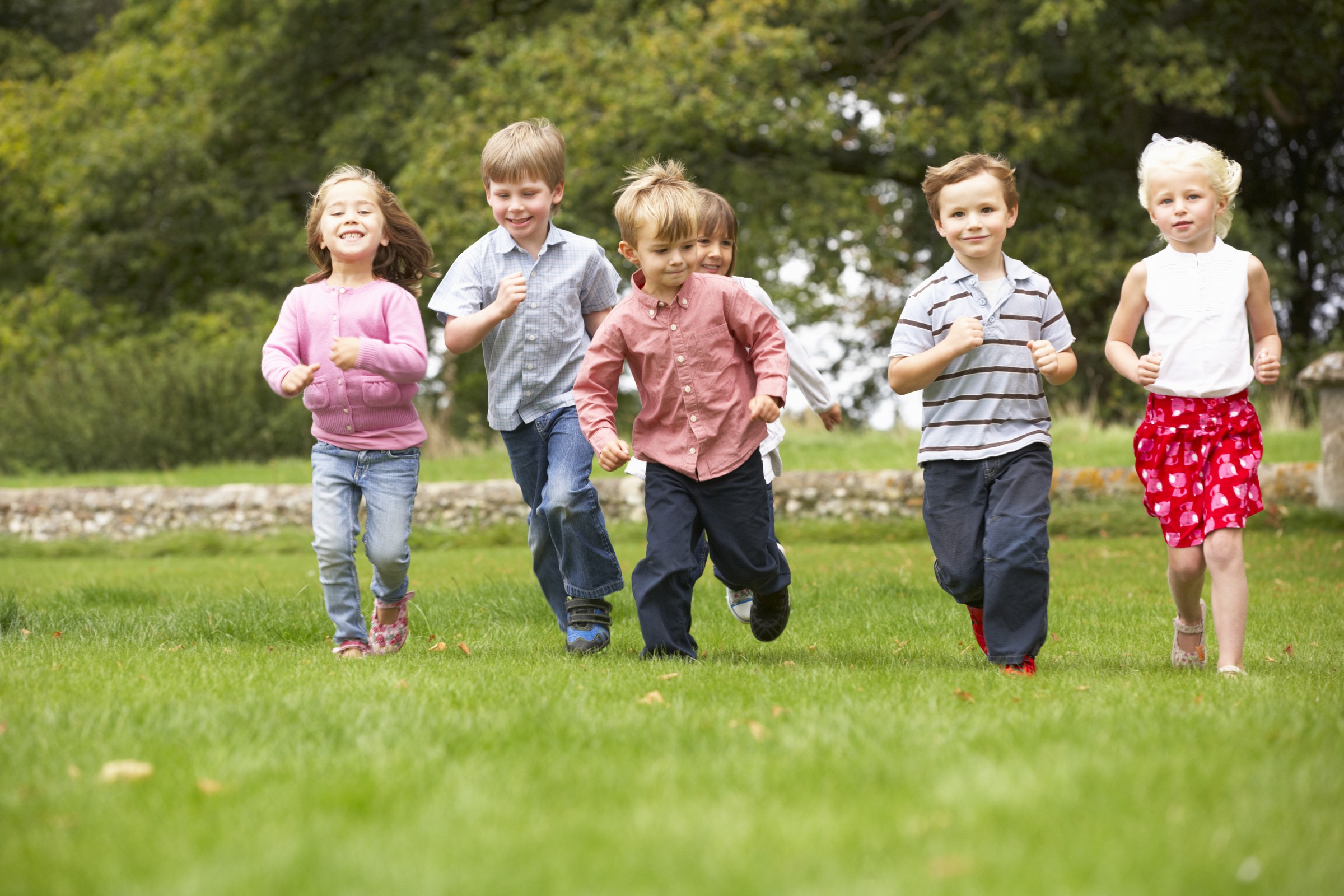 The children they are running. Дети бегают вокруг клумбы. Группа маленьких детей бежит. Фон для детей которым 6 лет. Для детей 6лет: что такое дружелюбие.